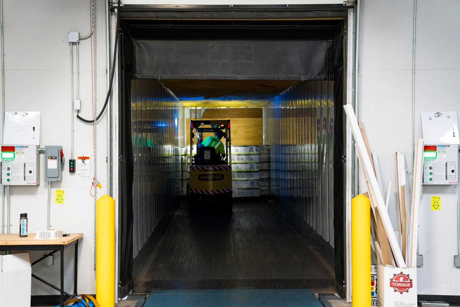 Forklift moving palletized goods through a cold-chain loading dock
